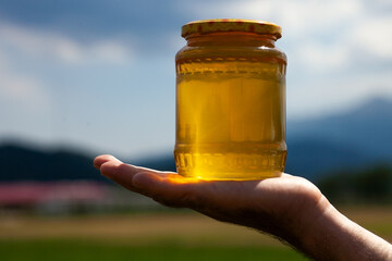 hand holding jar of honey