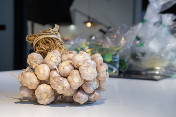 Garlic Bundle in studio light on the white marble surface table, prepare for a food demonstration...