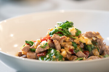 Completed and ready to serve, The Stir-Fried Beef Basil in Thai Food Style. It is in white bowl in studio light.