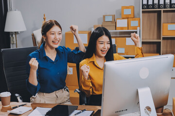 Asian SME business women use laptop computer checking customer order online shipping boxes at home....