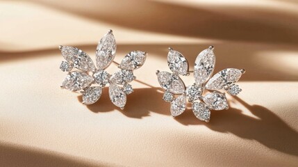 Fototapeta premium Dazzling cluster diamond earrings arranged on a champagne-colored surface.