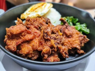A delicious dish containing crispy fried chicken, soft rice, fried egg, stir-fried vegetables, a delicious and perfect combination of food.