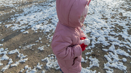 little girl playing on the playground on a winter day
