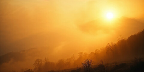 Fototapeta premium Golden sunrise illuminating foggy landscape with silhouetted trees