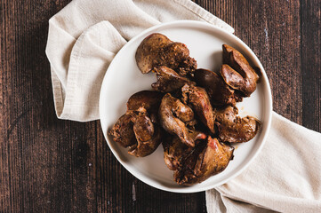 Close up of pieces of fried chicken liver on a plate on the table top view
