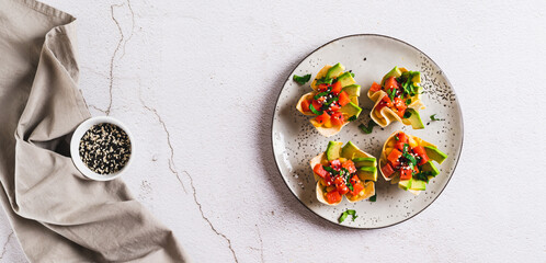 Poke bowls in pita bread with salmon and avocado on a plate top view web banner