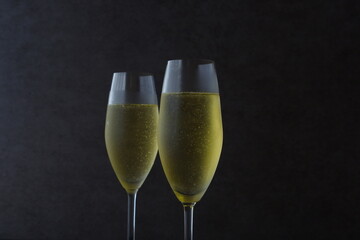 よく冷えたシャンパン（スパークリングワイン）が注がれたふたつのフルートグラスで、乾杯のイメージ
