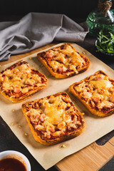 Homemade bread pizza with bacon and cheese on a board on the table vertical view