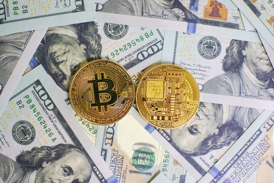 Close up of metal golden bitcoin crypto currency coins on US 100 dollar bills. Bitcoin coin and cash background