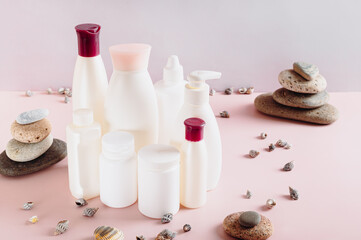 Set of various cosmetic bottles for feminine care on pink