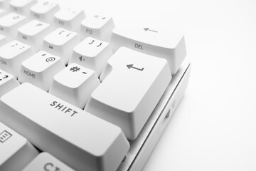 White, wireless gaming mechanical computer  keyboard. Closeup on the enter key, keycap. Minimal, modern design on white background. 60 percent keyboard. copy space.