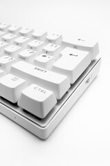 White, wireless gaming mechanical computer  keyboard. Closeup on the enter key, keycap. Minimal, modern design on white background. 60 percent keyboard. copy space.