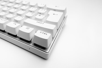 White, wireless gaming mechanical computer  keyboard. Closeup on the control key, keycap. Minimal, modern design on white background. 60 percent keyboard. copy space.