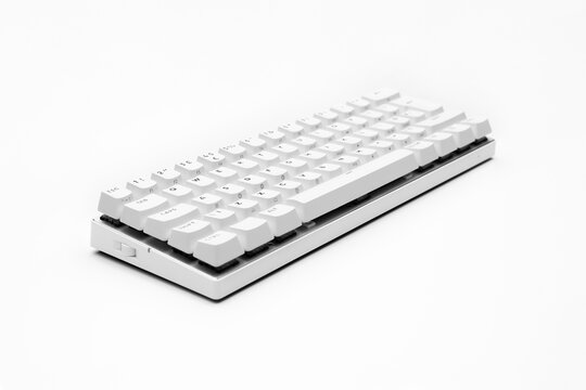White, wireless gaming mechanical computer  keyboard closeup, isolated. Minimal, modern design on white background. side view.  60 percent keyboard. copy space. Communication device.