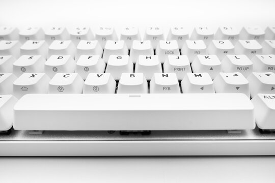 White, wireless gaming mechanical computer  keyboard. Closeup on the space bar key, keycap. Minimal, modern design on white background. Cyberspace. copy space. Data and communication. Macro key
