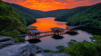 Obraz premium Serene Lake Sunrise with Wooden Piers Surrounded by Lush Green Hills