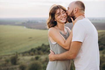 Obraz premium Romantic Couple Embracing and Enjoying a Sunset in a Scenic Rural Landscape