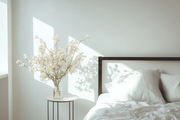 Sunlit bedroom with white flowers and linen bedding.
