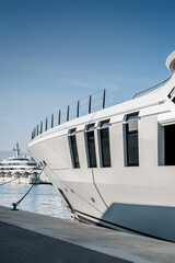 Naklejka premium Vertical shot from the stern of a superyachts and megayacht at dock located in Genova, Italy after shipyard maintenance 