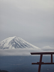 stunning view of snow capped mountain peak surrounded by clouds, framed by traditional wooden...