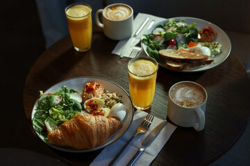Tasty breakfast. Different meals and drinks served on wooden table in cafe, closeup