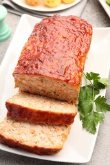 Delicious baked turkey meatloaf with parsley on table, closeup