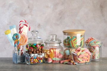 Candy bar. Many different sweets on wooden table against grey background. Space for text