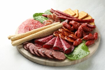 Different smoked sausages and other snacks on white table, closeup