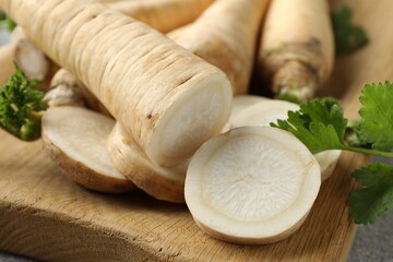Parsley roots and leaves on grey table, closeup