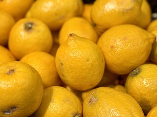 Ripe fresh yellow lemons on the shelf of a fruit supermarket are displayed for sale