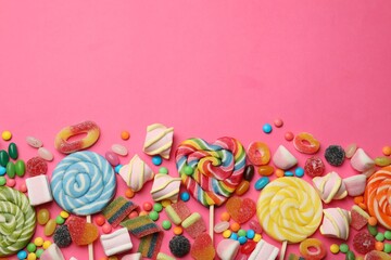 Different delicious candies and marshmallows on pink background, flat lay. Space for text