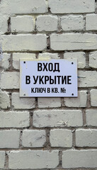 Obraz premium entrance to the shelter, sign on the brick wall in Russian 