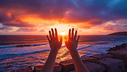 The girl's hands on the background of sunset and sea waves. Human hands on the background of a seascape in the setting sun.