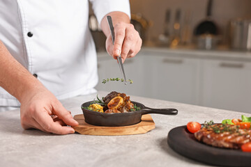 Professional chef serving dish at table indoors, closeup