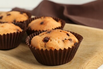 Delicious muffin with chocolate chips on table, closeup