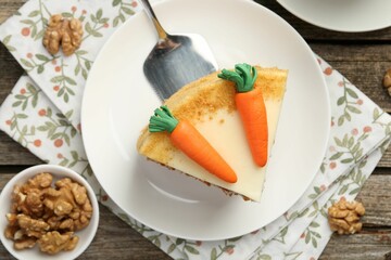 Piece of delicious homemade carrot cake and walnuts on wooden table, flat lay