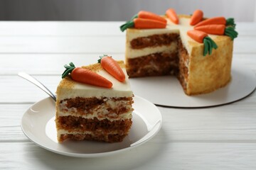 Delicious homemade carrot cake on white wooden table