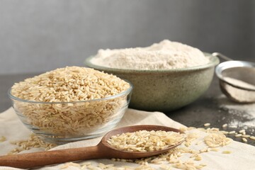 Brown rice and flour on grey table, closeup
