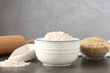 Brown rice and flour on grey table. Space for text