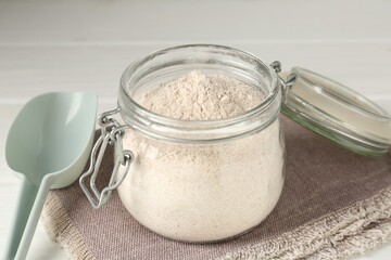 Brown rice flour on white wooden table, closeup