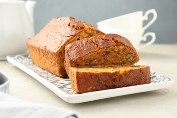 Cut homemade carrot cake with nuts on light grey table, closeup