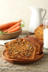 Homemade carrot cake with nuts, milk and vegetables on wooden table, closeup