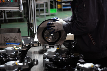 Factory automation production line. Automotive parts production line. Workers are producing car brake discs and various components in the machining workshop. Inside the automotive intelligent factory