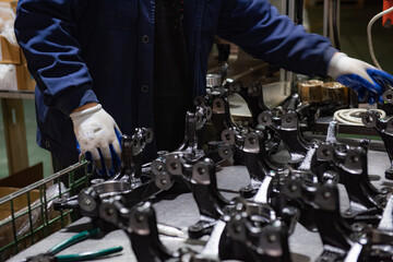 Factory automation production line. Automotive parts production line. Workers are producing car brake discs and various components in the machining workshop. Inside the automotive intelligent factory