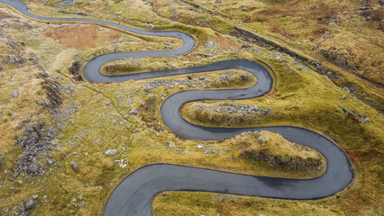 Aerial view of narrow winding road in mountainous area 