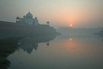 Naklejka premium Sunrise over foggy Taj Mahal reflection in water.