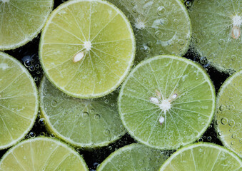 Close up of fresh lime slice in sparkling water with bubbles