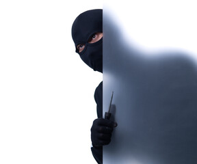 Studio shot of a stealthy thief breaking into a room and carefully looking around isolated on white...