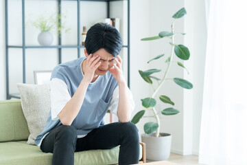 リビングで悩む若い男性