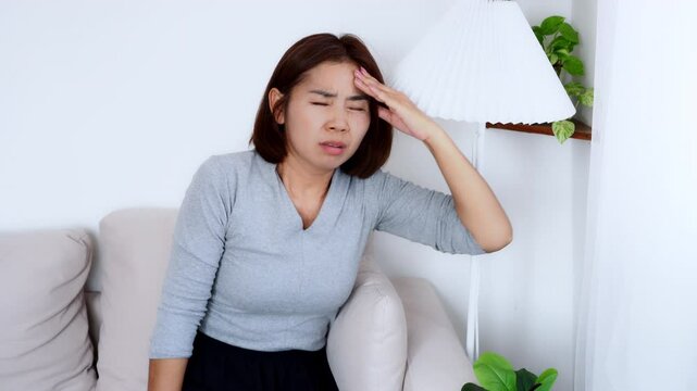Asian Woman experiencing fainting, dizziness, and lightheadedness from low blood pressure or orthostatic hypotension while standing